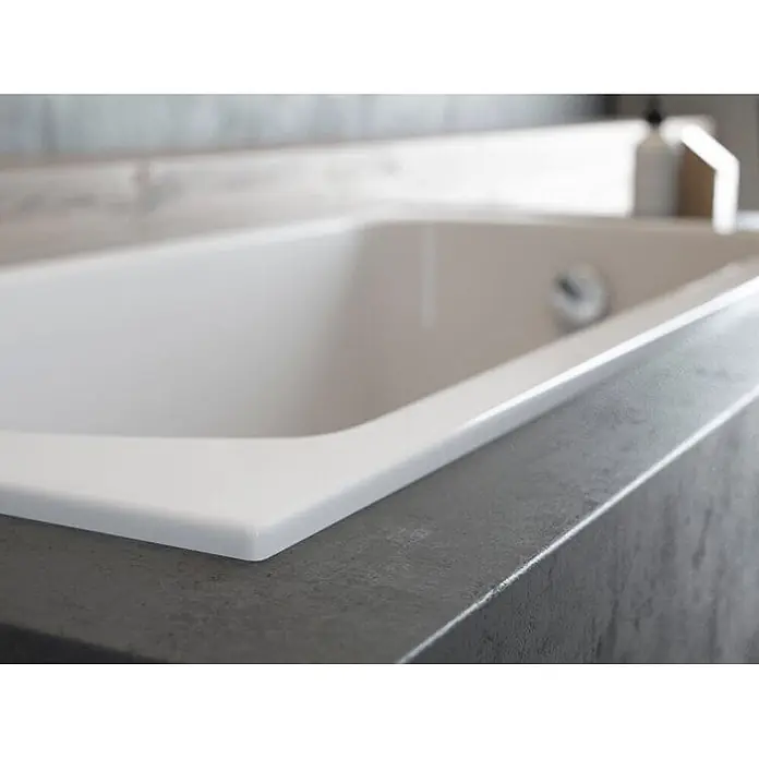 Bad Land Badewanne CLASSIC SLIM Acryl-Eckwanne 150 x 75 cm Weiß, inkl. Wannenträger - 150 x 75 cm, Sanitäracryl, Weiß - Weiße Einbau-Badewanne mit glänzender Oberfläche, bündig in eine strukturierte dunkelgraue Arbeitsplatte eingelassen.