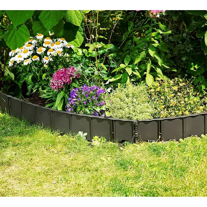 Garantia Rasenkante Edgar - Anthrazit, 75 x 0,6 x 13 cm, Polypropylen - Eine dekorative, schwarze Beeteinfassung aus Kunststoff umschließt ein Blumenbeet mit bunten Blumen und grünem Gras.