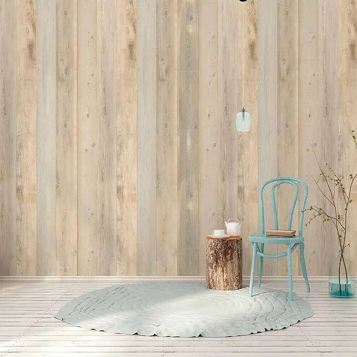 Grosfillex Wandpaneel Element 3D - Nordic, 2.600 x 375 x 8 mm - Dieses Bild zeigt ein stilvolles Interieur mit einem blauen Stuhl, einem Baumstumpf-Beistelltisch und einem runden Teppich. Die Holzpaneele an der Wand sorgen für Wärme.