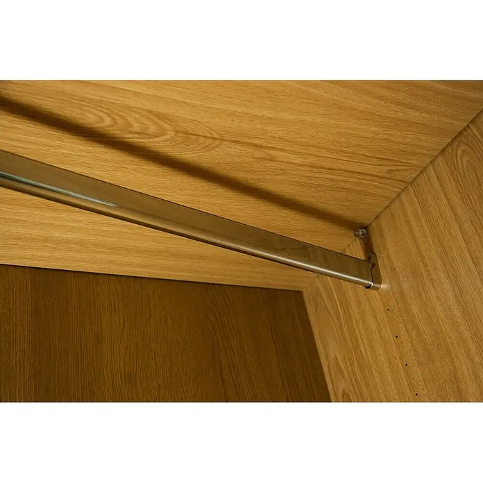 M.Pascual Barra para ropa lisa - Largo: 2.000 mm, Cromo, Ovalada - Barra de ropa cromada brillante instalada dentro de un armario de madera clara, lista para colgar prendas.