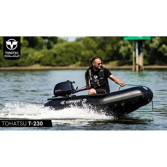 Tohatsu Schlauchboot Allroundmarin T230 - L x B: 235 x 142 cm, Geeignet für: 3 Personen, Nutzlast: 400 kg - Schwarzes Tohatsu T-230 Schlauchboot mit Person am Steuer, das eine deutliche Bugwelle auf dem Wasser erzeugt.