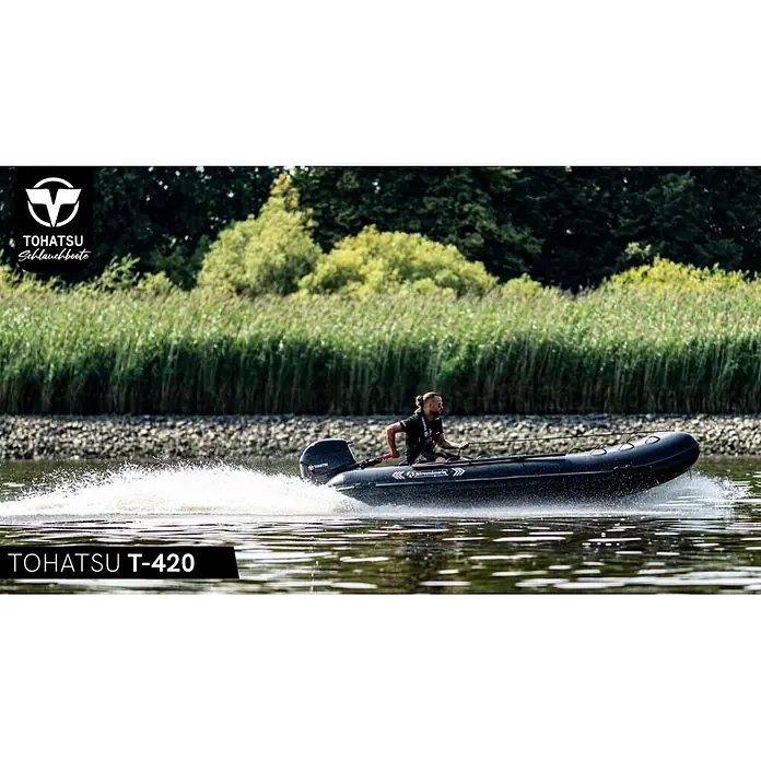 Tohatsu Schlauchboot Allroundmarin T420 - L x B: 418 x 200 cm, Geeignet für: 7 Personen, Nutzlast: 1.000 kg - Schwarzes Tohatsu T-420 Schlauchboot mit Außenborder, von einem Mann bedient, rast auf dem Wasser und erzeugt eine weiße Bugwelle.