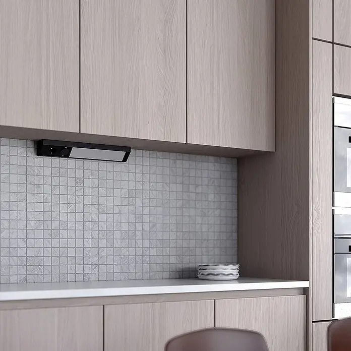 Arcchio LED-Unterbauleuchte Mitari - L x B x H: 46,6 x 7 x 7 cm - Schwarze Unterbauleuchte mit Drehreglern, montiert unter hellen Holzschränken über einem gefliesten Spritzschutz.