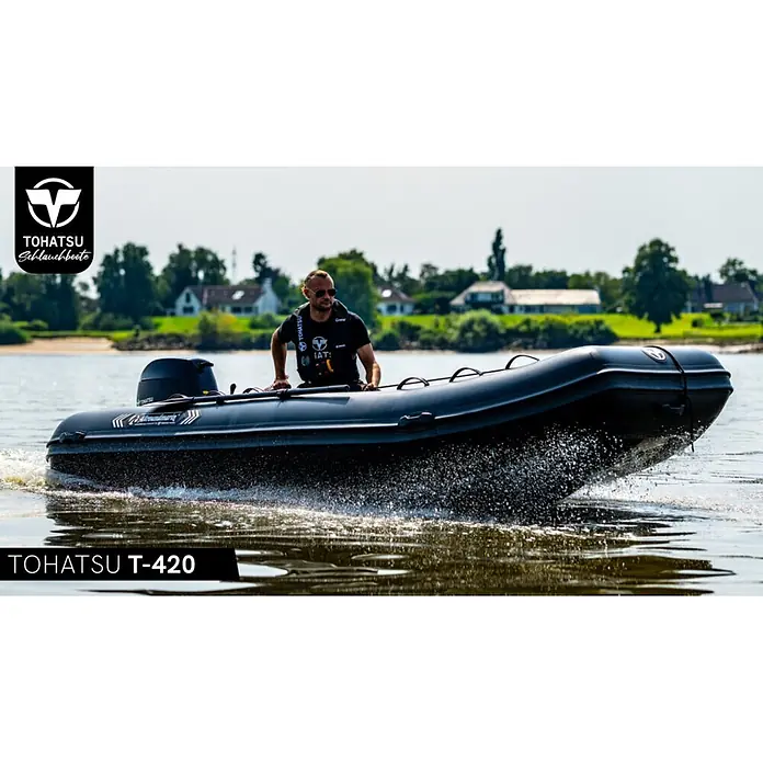 Tohatsu Schlauchboot Allroundmarin T420 - L x B: 418 x 200 cm, Geeignet für: 7 Personen, Nutzlast: 1.000 kg - Schwarzes Tohatsu T-420 Schlauchboot mit einem Mann am Steuer auf dem Wasser, Gischt erzeugend.