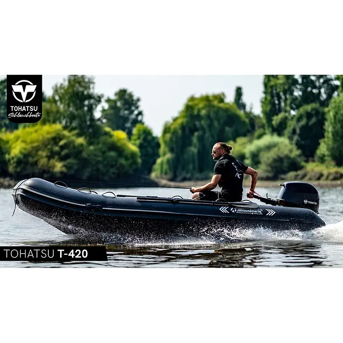 Tohatsu Schlauchboot Allroundmarin T420 - L x B: 418 x 200 cm, Geeignet für: 7 Personen, Nutzlast: 1.000 kg - Schwarzes Schlauchboot mit Außenbordmotor, von einem Mann auf dem Wasser gefahren, Gischt erzeugend.
