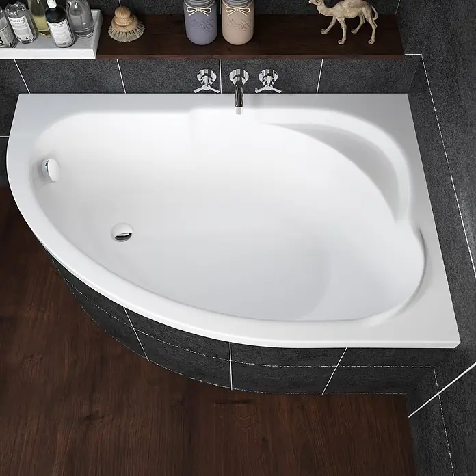 Bad Land Eckbadewanne - L x B: 130 x 85 cm, Sanitäracryl, Weiß - Weiße Eckbadewanne in einem modernen Bad mit dunklen Fliesen und Holzboden. Mit Chromarmaturen.