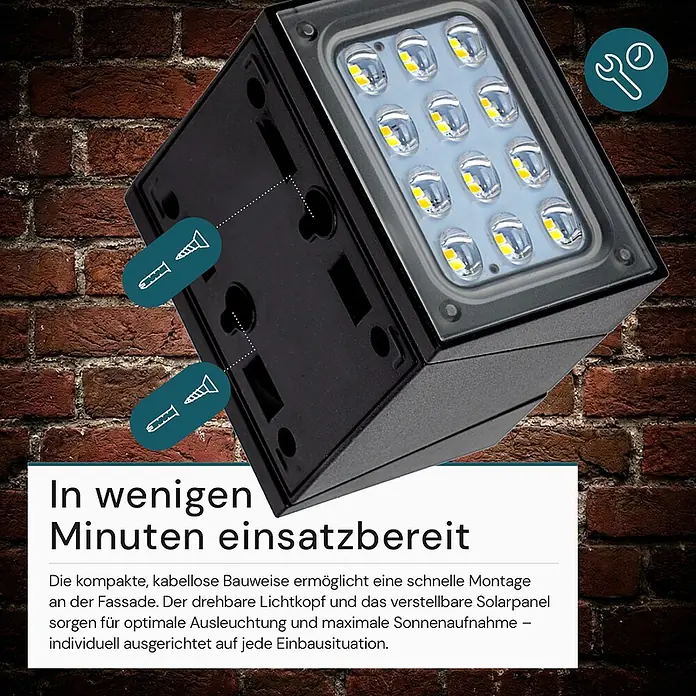Luxula Solar-Außenwandleuchte - Schwarz, IP65, 300 lm - Schwarze, kubische Solar-LED-Leuchte mit Montagepunkten an einer Ziegelwand.