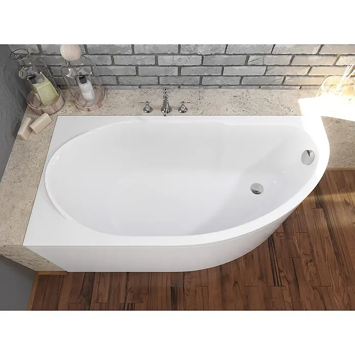Bad Land Eckbadewanne MIKI Acryl-Eckwanne 145 x 85 cm links Weiß - Sanitäracryl, Weiß - Weiße Einbau-Badewanne mit asymmetrischem, geschwungenem Design, integriert in eine helle Steinoberfläche mit Chromarmaturen in einem modernen Bad.