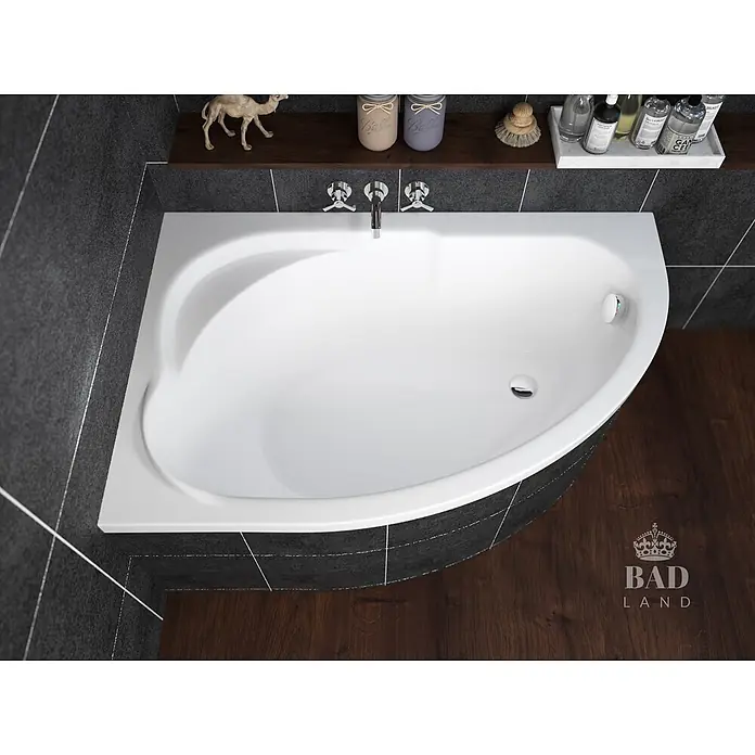 Bad Land Eckbadewanne STANDARD Acryl-Eckwanne 130 x 85 cm links Weiß - Sanitäracryl, Weiß - Weiße Eckbadewanne mit Wandarmaturen in einem modernen Badezimmer mit dunklen Fliesen und Holzboden.