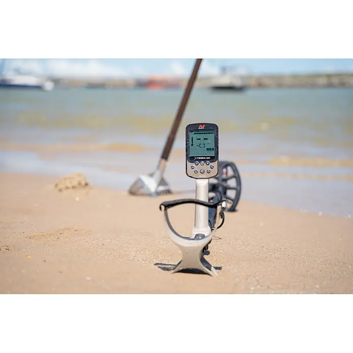 Minelab Metalldetektor X-TERRA ELITE Expidition - 3,7 V, 1 Akku, 5.100 mAh, L x B x H: 230 x 310 x 1.380 mm - Minelab X-TERRA Elite Metalldetektor mit schwarzem und beigem Steuergerät am Sandstrand, bereit zur Schatzsuche.