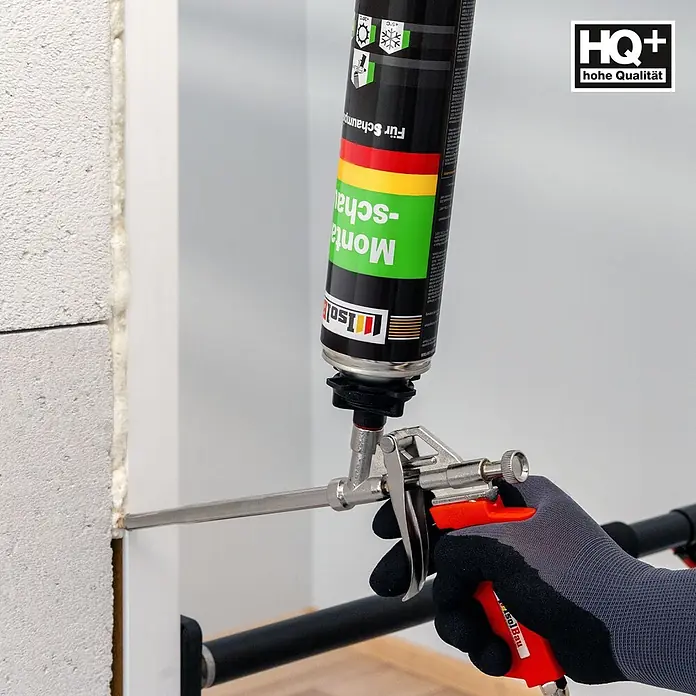 IsolBau Bauschaum 1 x Montageschaum 750 ml, PU-Reiniger 500 ml, Schaumpistole - 750 ml - Behandschuhte Hand trägt Montageschaum aus Dose mit Schaumpistole in Wandfuge auf.