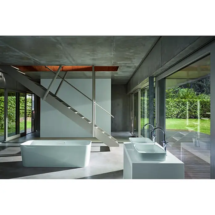 Bette Waschtisch - 400 x 300 cm - Eine moderne weiße freistehende Badewanne und zwei weiße eckige Waschbecken in einem minimalistischen Bad mit großen Fenstern.
