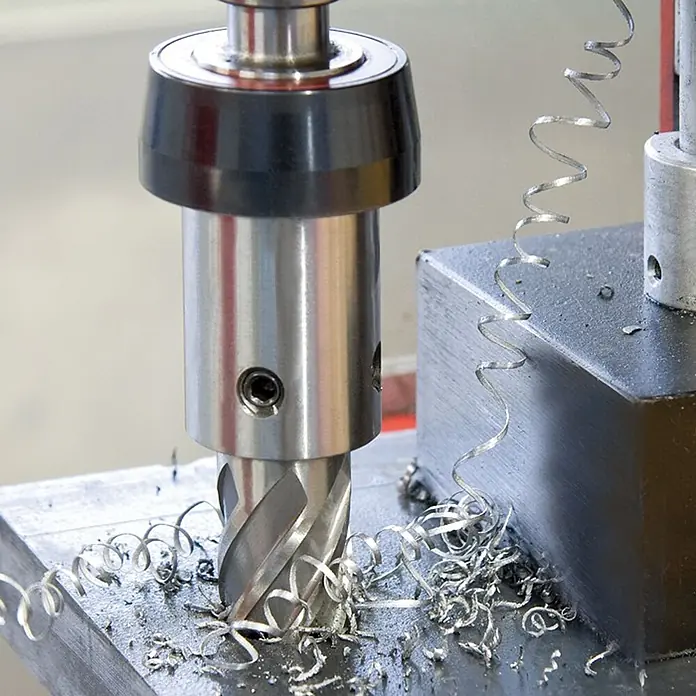 Ruko Kernbohrmaschine RU40 -  - Metallfräswerkzeug schneidet ein Metallwerkstück und erzeugt silbrige Späne.