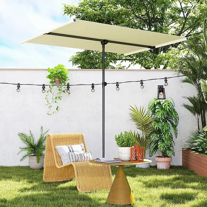 Outsunny Marktschirm - Beige - Cremefarbener, rechteckiger Sonnenschirm beschattet einen Korbstuhl und Tisch im Garten.