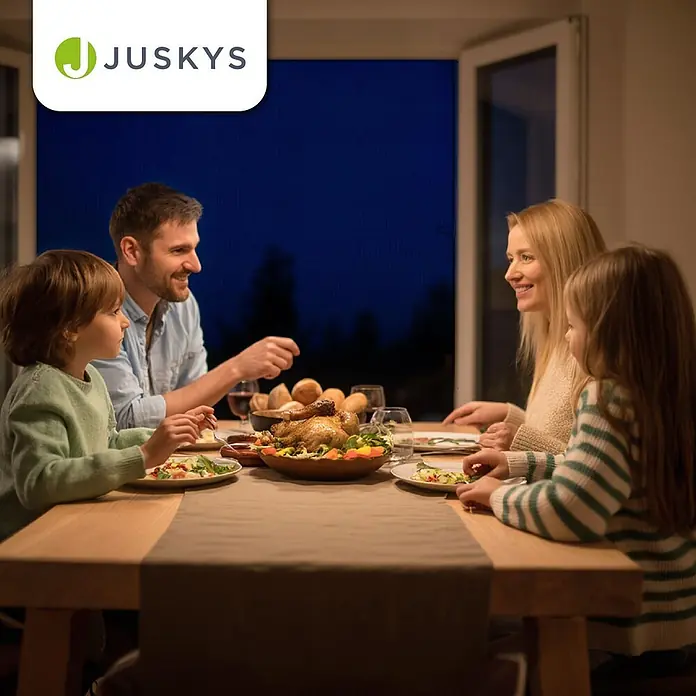 Juskys Insektenschutzfenster Fliegenschutzgitter - B x H: 120 x 140 cm, Montage Insektengitter: Klemmen - Ein brauner Stoff-Tischläufer auf einem Holztisch, an dem eine Familie isst.