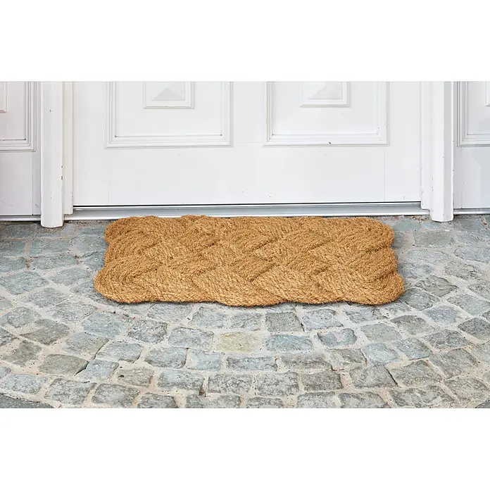 Fußmatte Nature Classic - 75 x 45 cm, Natur, Material Nutzschicht: 100 % Kokos - Geflochtene Fußmatte aus Kokosfaser in Naturbeige vor einer weißen Tür auf Pflastersteinen.