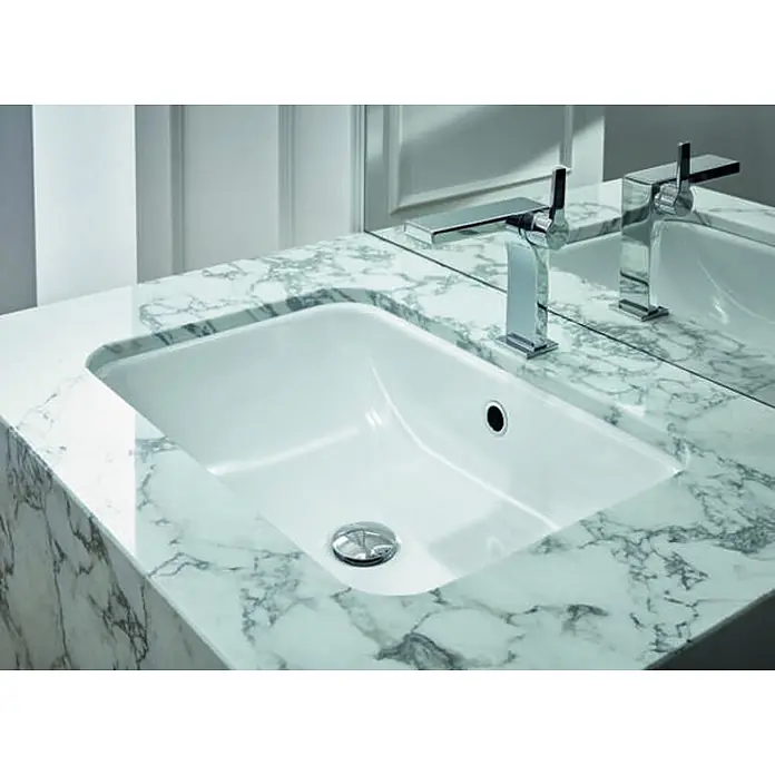 Bette Unterbauwaschbecken -  - Weißes rechteckiges Keramikwaschbecken, in eine weiße Marmorarbeitsplatte integriert, mit modernem Chromwasserhahn.