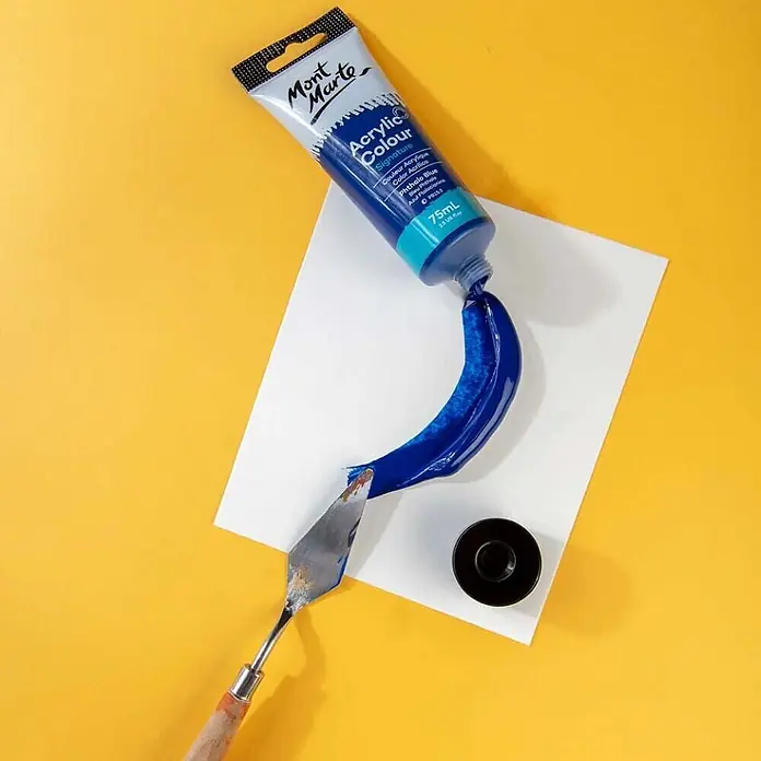 Mont Marte Acrylfarbe Signature - Phthaloblau, 75 ml, Tube - Mont Marte Phthalo Blau Acrylfarbe aus der Tube auf eine weiße Fläche gedrückt, daneben ein Spachtel.