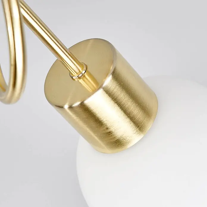 Lindby Deckenleuchte Elaina - messing / gold, E14 - Zylinderförmiges, gebürstetes Goldmessing-Bauteil einer Leuchte mit Stange, auf einem weißen Diffusor.