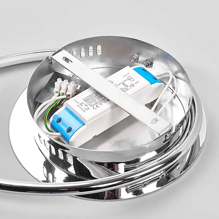 Lindby Deckenleuchte Joline - chrom / silber - Innenansicht einer verchromten Leuchtenbasis mit weißem LED-Treiber, blauen Akzenten und mehrfarbiger Verkabelung zur Installation.