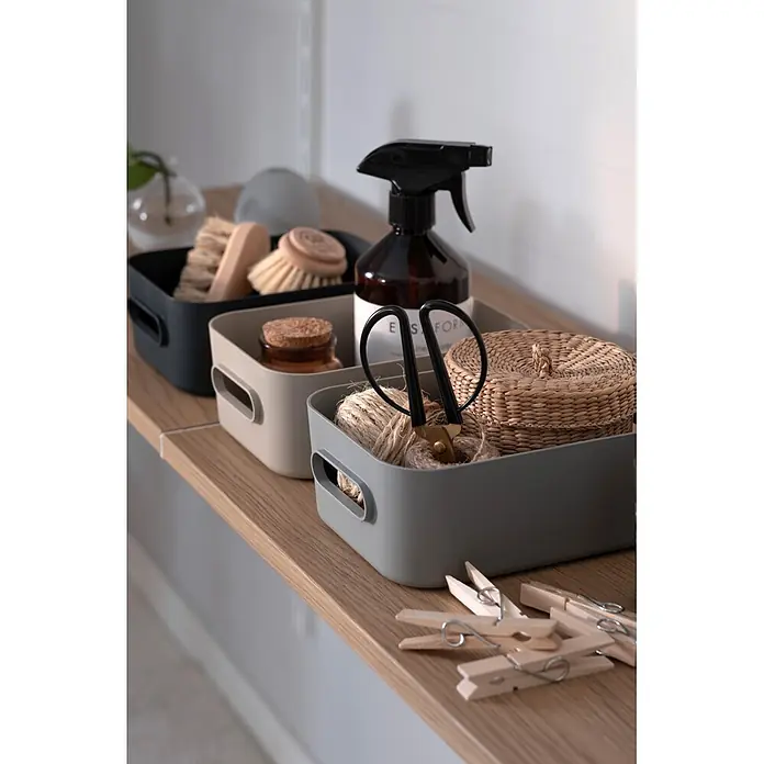 SmartStore Aufbewahrungsbox Comfort S - L x B x H: 20 x 14 x 7,5 cm, Kunststoff, Dark Teal, 1,5 l - Organisiertes Regal mit schwarzen, beigen und grauen Aufbewahrungsboxen für Reinigungsmittel, Bastelutensilien und Korb, daneben Wäscheklammern.