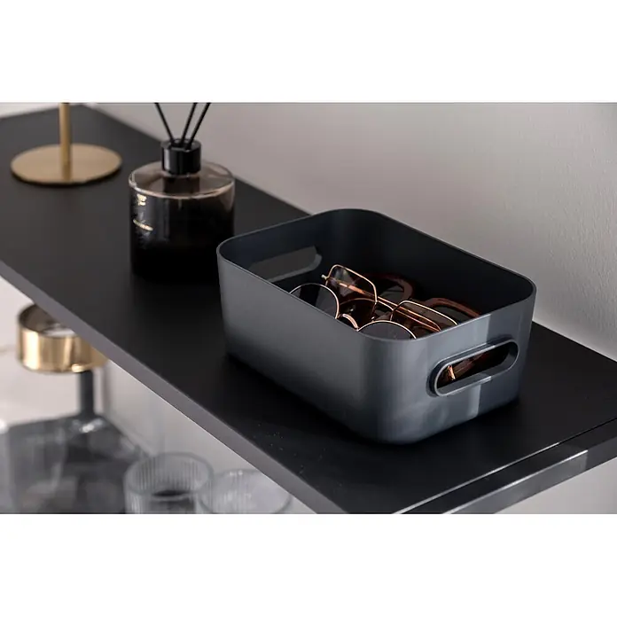 SmartStore Aufbewahrungsbox Comfort S - L x B x H: 20 x 14 x 7,5 cm, Kunststoff, Dark Teal, 1,5 l - Dunkelgraue rechteckige Aufbewahrungsbox mit integrierten Griffen, gefüllt mit Sonnenbrillen, auf einem dunklen Regal.