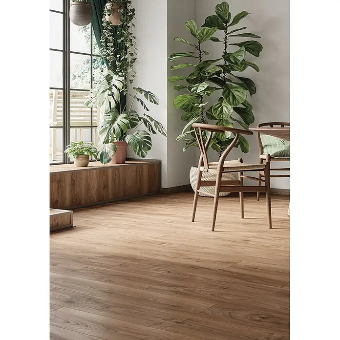 Krono Original Laminat Classic Silent - Historic Oak, Landhausdiele, 1.288 x 195 x 9 mm - Heller Holzboden in einem Raum mit großen Pflanzen und Holzstühlen. Der Boden zeigt natürliche Holzmaserung.