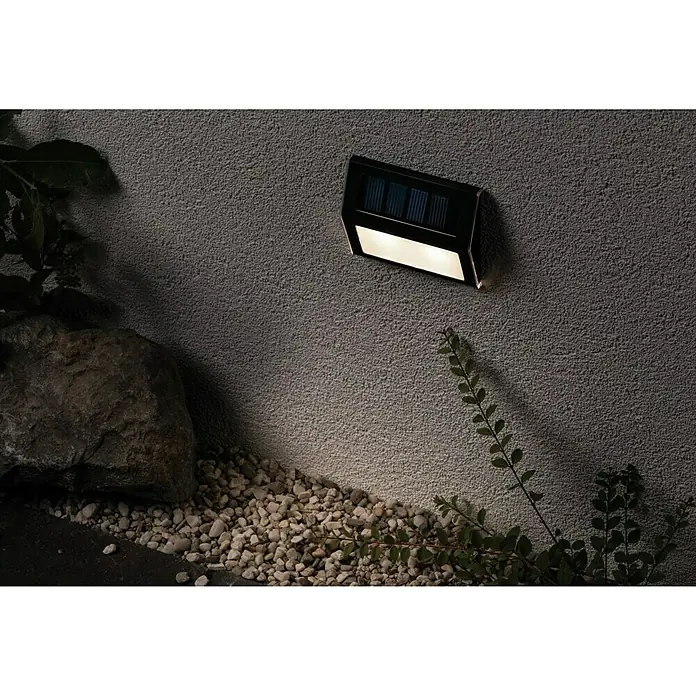 Paulmann Solar-Außenwandleuchte Dayton - 0,05 W, Schwarz, IP44 - Nahaufnahme einer Solarleuchte an einer Wand, die sanft den Untergrund beleuchtet und eine stimmungsvolle Atmosphäre schafft.