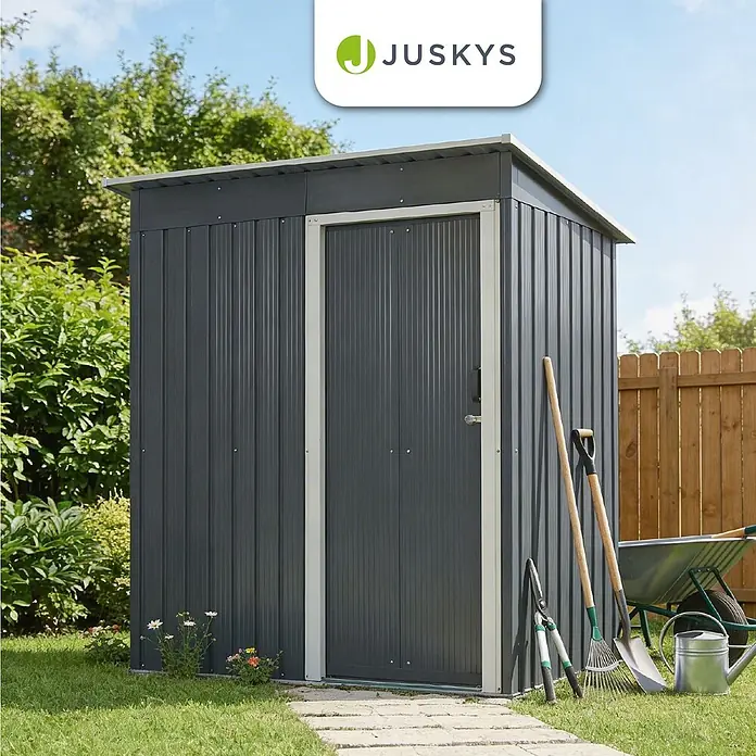 Juskys Gerätehaus Gerätehaus - Metall, grau - Dunkelgrauer Metall-Gartenschuppen im Garten. Gartengeräte lehnen daran, was seine Funktion als Lagerraum zeigt.