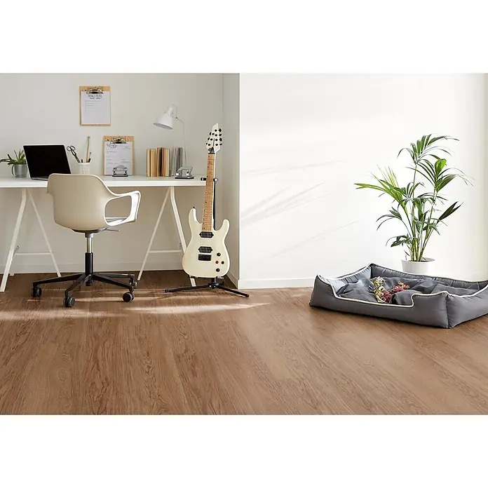 Decolife Designboden Freestyle Access Hazelnut Oak - 1.220 x 185 x 8,5 mm, Landhausdiele, Hazelnut Oak - Ein modernes Homeoffice mit weißem Schreibtisch, Stuhl, Laptop, weißer E-Gitarre, Pflanze und grauem Haustierbett auf Holzboden.