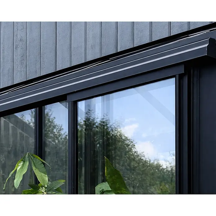Bloomcabin Gewächshaus Aluminium Mini - Außenmaß inkl. Dachüberstand (B x T): 120 x 66 cm, Material Seitenwand: Glas, 4 mm, Schwarz - Modernes schwarzgerahmtes Schiebefenster mit reflektierendem Glas und einer oberen Blende, in eine dunkelgraue Holzfassade integriert.