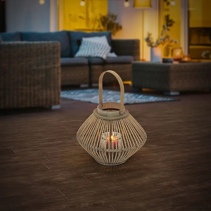 ECD Germany Windlicht Boho Bambus Laterne - Ø x H: 31 x 42 cm, Natur, 1 Stk. - Naturfarbene Bambuslaterne mit brennender Kerze, die einen dunklen Holzboden in gemütlicher Außenumgebung beleuchtet.