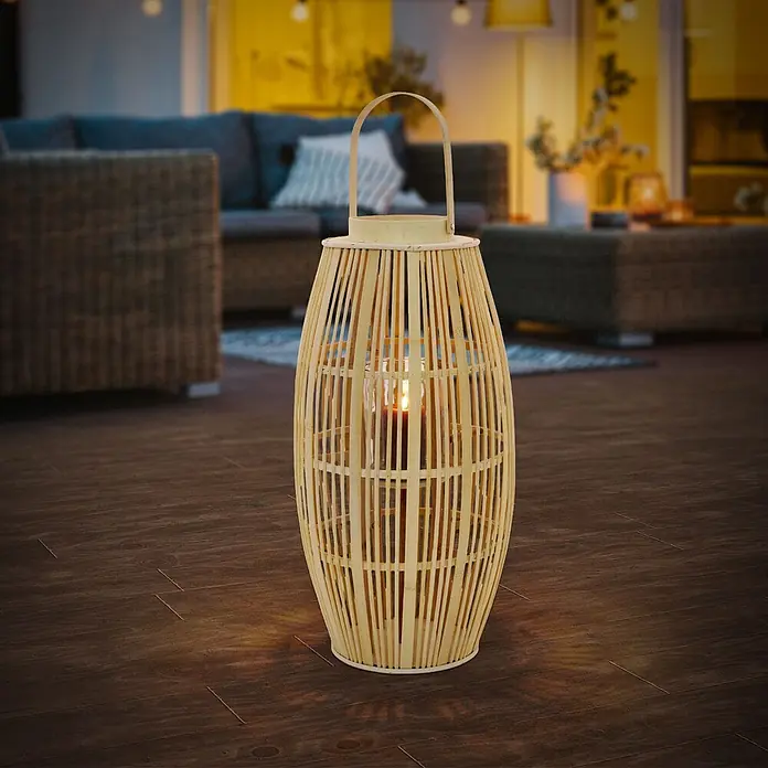 ECD Germany Windlicht Boho Bambus Laterne - Ø x H: 30 x 75 cm, Natur, 1 Stk. - Helle Bambuslaterne mit brennender Kerze, die einen dunklen Holzboden in gemütlicher Umgebung beleuchtet.