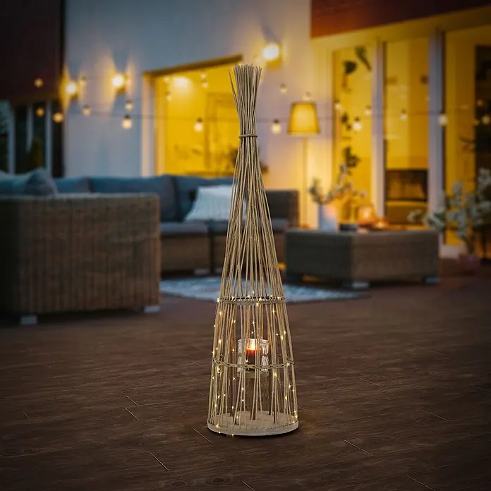 ECD Germany Windlicht Boho Bambus Laterne - Ø x H: 34 x 132 cm, Natur, 1 Stk. - Hohe, konische Außenlaterne aus Naturholzstäben, mit Lichterkette und Kerze auf einer Terrasse.