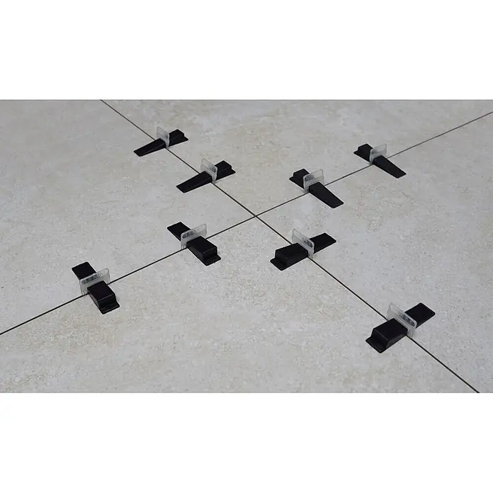 Heka Nivofix Keile - 100 Stk. - Schwarze Fliesen Nivellierkeile mit transparenten Clips auf hellen Fliesen. Einige Clips zeigen "1.5 MM".