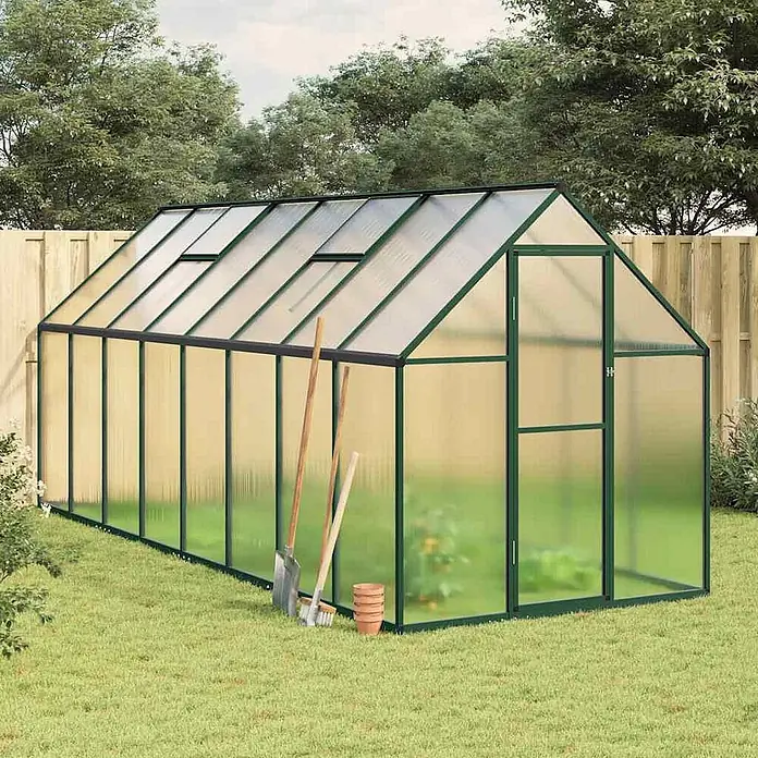 Furnicato Gewächshaus - 169 x 445 cm, Material Seitenwand: Kunststoff, 38 mm, silber - Gewächshaus mit dunkelgrünem Rahmen, lichtdurchlässigen Platten, Dachluken und Tür, im Garten mit Werkzeugen.