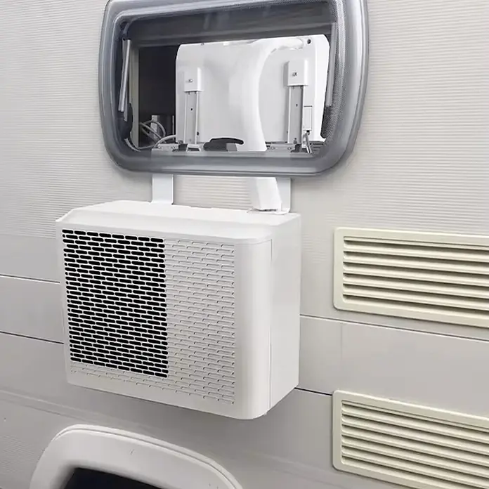 Sannover Mobiles Klimagerät - 1,5 kW, Raumgröße: 12 m², weiß - Weißes tragbares Klimagerät an einem Wohnwagenfenster montiert, mit externem Gitter und internen Komponenten.