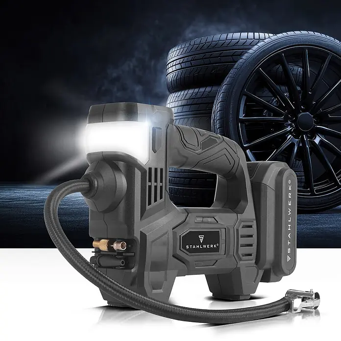 STAHLWERK Kompressor ADK-20 ST - 72 W, Schmierung: Ohne - Dunkelgrauer tragbarer Reifenfüller mit LED-Licht, Schlauch und Akku, vor dunklem Hintergrund mit Autoreifen.
