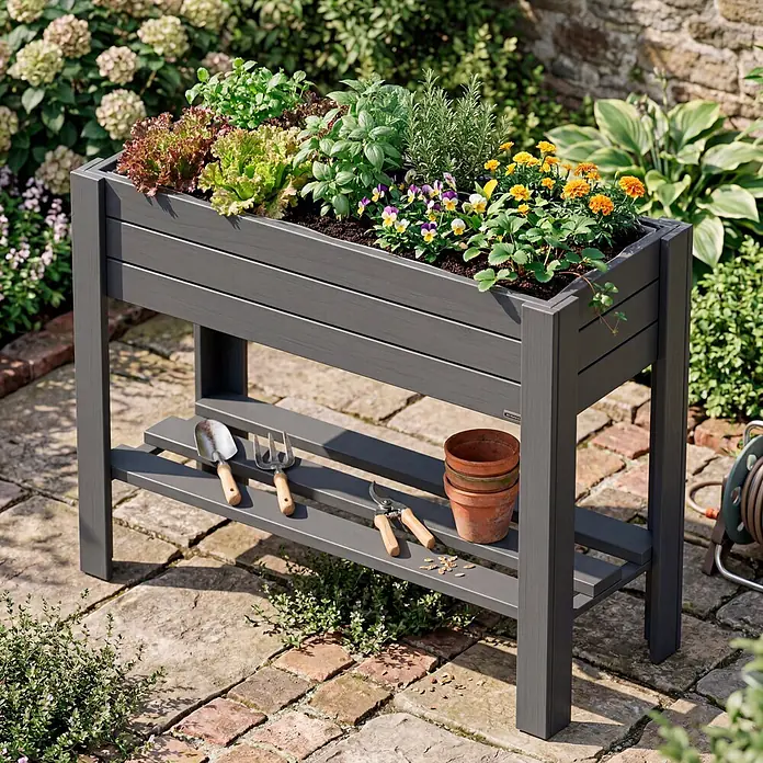 Wagner System GreenFamily Hochbeet GreenBOX light - 83 x 34,5 x 70 cm, Holz, Anthrazit - Graues Hochbeet mit Regal, bepflanzt mit Kräutern, Salat und Blumen, auf Pflastersteinen im Garten.