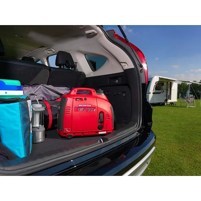 Honda Stromerzeuger EU 10i - Nennleistung: 1,1 kW, Tankvolumen: 2,1 l - Roter Honda EU10i Inverter-Generator im Kofferraum eines Autos mit Campingausrüstung für den Außeneinsatz.