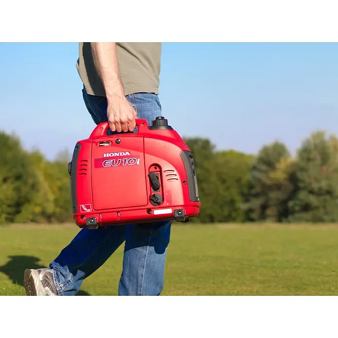 Honda Stromerzeuger EU 10i - Nennleistung: 1,1 kW, Tankvolumen: 2,1 l - Eine Person trägt einen roten Honda EU10i Inverter-Generator mit schwarzem Griff.