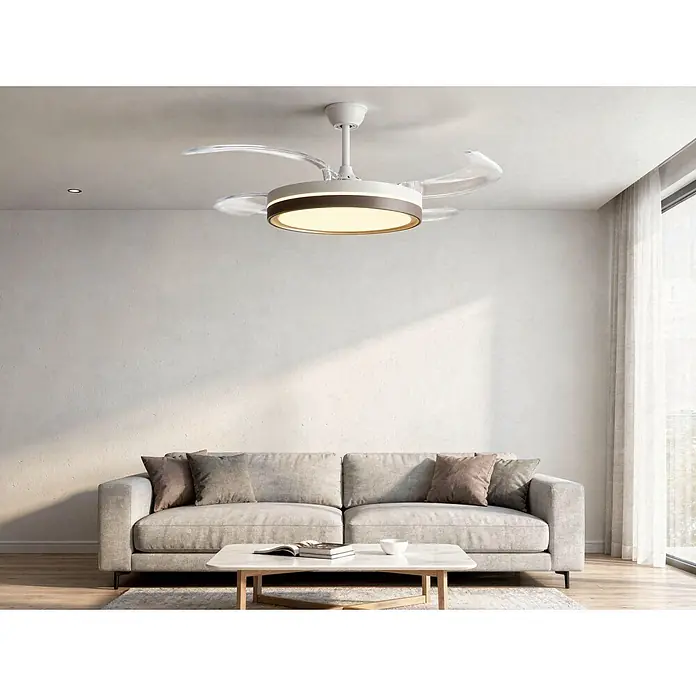 Purline Ventilador de techo Ceily Brise - Blanco/Madera oscura, 107 cm, 28 W, Blanco neutro - Ventilador de techo moderno blanco con aspas retráctiles transparentes y luz LED circular central, instalado en una sala de estar.