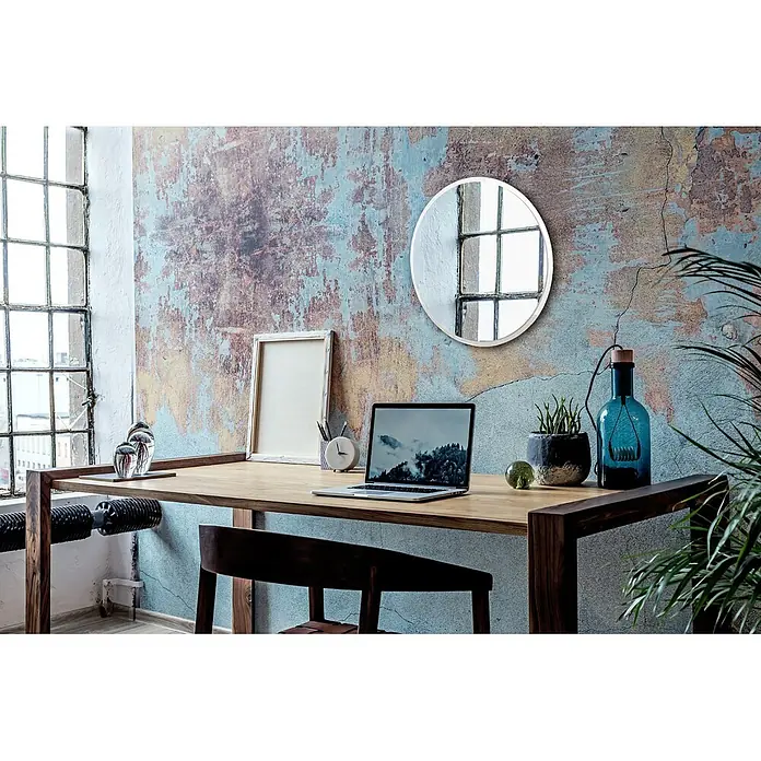 Tulup Wandspiegel - 100 x 100 cm - Ein schlichter Holzschreibtisch mit Laptop und Accessoires vor einer Wand im Industriestil.
