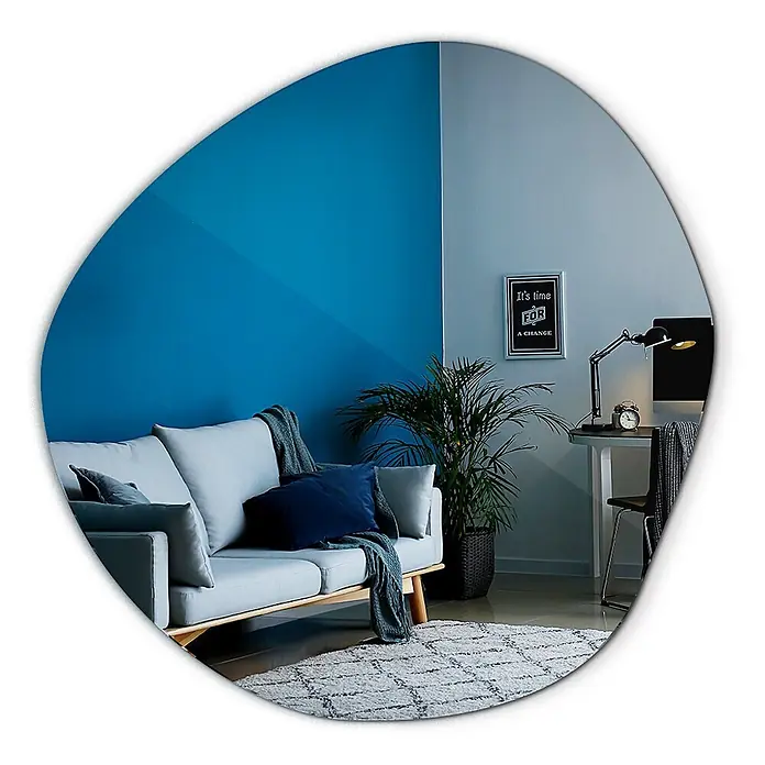 Tulup Wandspiegel - 95,7 x 96,5 cm - Unregelmäßig geformter Spiegel, der ein modernes Wohnzimmer mit blauen Akzentwänden, einem grauen Sofa und einem Schreibtischbereich widerspiegelt.