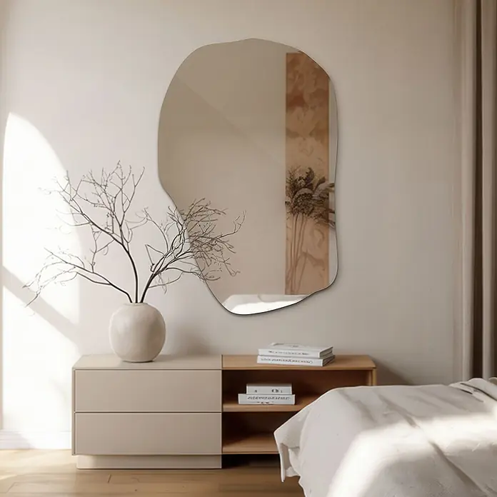 Tulup Wandspiegel - 65 x 100 cm - Organisch geformter Wandspiegel, der ein sonnendurchflutetes Schlafzimmer über einer minimalistischen Kommode widerspiegelt.