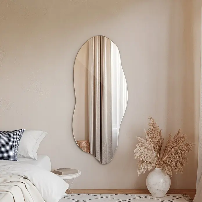 Tulup Wandspiegel - 80 x 45 cm - Großer, rahmenloser, unregelmäßig geformter Spiegel in einem modernen Schlafzimmer, der Licht und Vorhänge reflektiert.