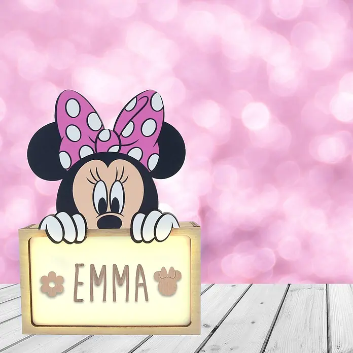 Lámpara de sobremesa infantil Minnie Mouse - 0,5 W, L x An x Al: 5 x 12,5 x 17 cm, Marrón, Luz nocturna, Minnie Mouse - Minnie Mouse asoma sobre un letrero luminoso de madera personalizado con 'EMMA' sobre fondo bokeh rosa.