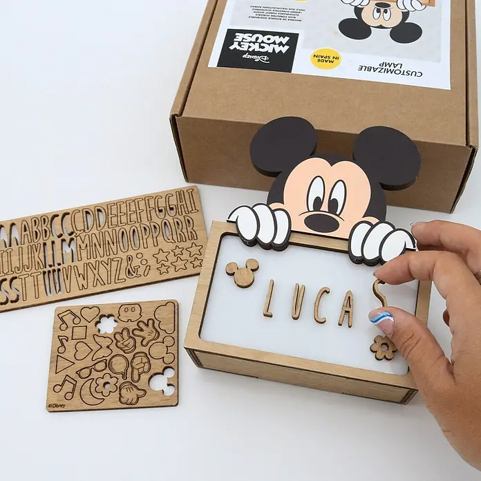 Lámpara de sobremesa infantil Mickey Mouse - 0,5 W, L x An x Al: 5 x 12,5 x 17 cm, Marrón y Negro, Luz nocturna, Mickey Mouse - Kit de lámpara personalizable de madera de Mickey Mouse con letras y formas. Una mano coloca una letra, formando 'LUCAS'.