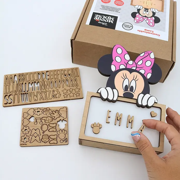 Lámpara de sobremesa infantil Minnie Mouse - 0,5 W, L x An x Al: 5 x 12,5 x 17 cm, Marrón, Luz nocturna, Minnie Mouse - Kit de lámpara personalizable de madera Minnie Mouse con letras y formas. Una mano coloca una 'A' de madera en la lámpara.