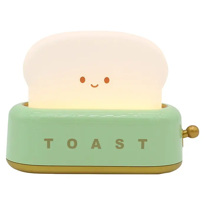 Lámpara de sobremesa Tostadora - Tostadora, 3 W, L x An x Al: 5,4 x 13,4 x 9,8 cm - Una luz nocturna brillante con forma de tostada con cara linda, base de tostadora verde menta con texto 'TOAST' y detalles dorados.